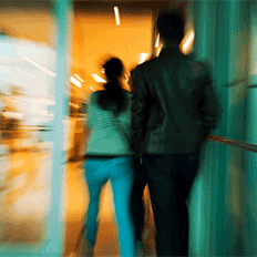 Two people walking into a building